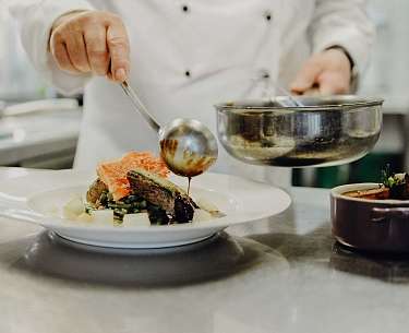 Chefkoch beim Eindecken des Tellers in Romantik Hotel Köllner's Landhaus