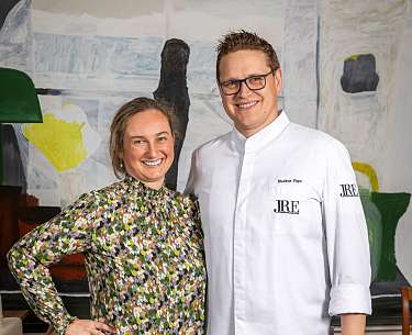 Ein Küchenchef und seine Frau lächeln in die Kamera