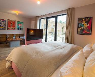 Blick auf ein Hotelzimmer mit Bett und Bildern an der Wand