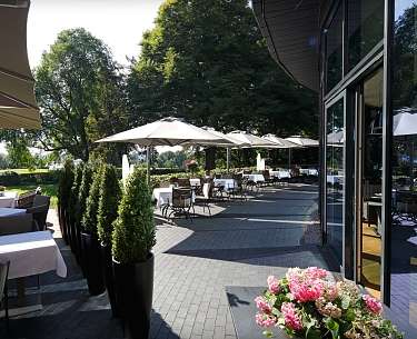 Blick auf die Terasse des Kieler Kaufmann mit eingedeckten Tischen bei Sonnenschein