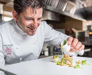 Der Chefkoch richtet das luxuriöse Essen in einem Hotel mit Sterneküche an 