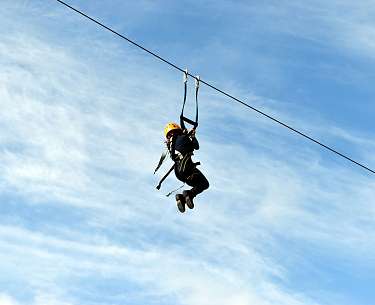 Person, die gerade an einer Zipline entlanggleitet