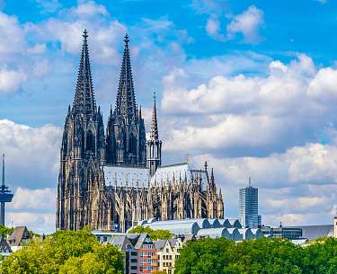 Außenansicht vom Kölner Dom bei blauem Himmel mit Wolken