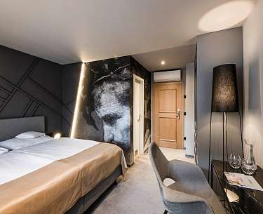 Stylisches, modernes Hotelzimmer mit anthrazitfarbenen Details und Wandgemälde