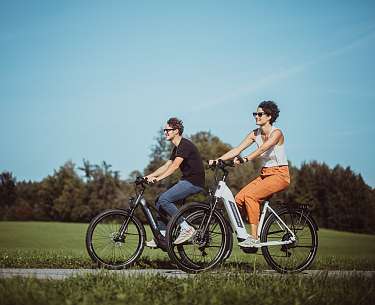 E-Bike und Rucksack auf einer grünen Wiese im Salzburgerland