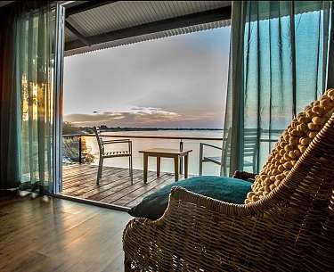 Gemütlicher Sessel in der Zambezi Mubala Lodge mit Blick auf den Sambesi, Namibia