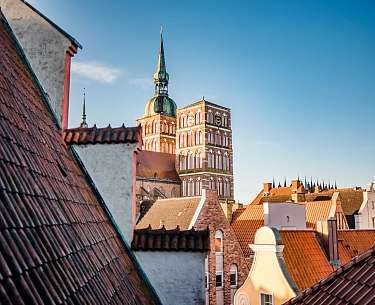 Ein Pärchen sitzt mit einem Blumenstrauß im Kunsturlaub am Ufer eines Flusses 