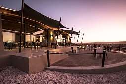 Restaurant-Veranda von The Desert Grace Lodge bei Sonnenuntergang, Namibia