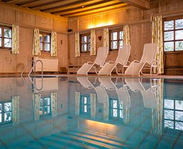 Indoor-Pool mit Sonnenliegen