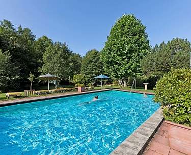 Pool mit traumhaftem Blick auf grüne Berge und Wiesen