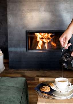 In einem exklusiven Wellnesshotel wird Tee an einem Lagerfeuer eingeschenkt 