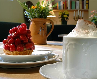 Tasse Kaffee und Stück Erdbeerkuchen