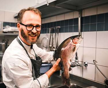 Gastgeber Andreas Rehberger mit Fisch in der Hand