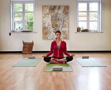 Frau praktiziert Yoga-Sitz im Romantik Hotel Mühlbach