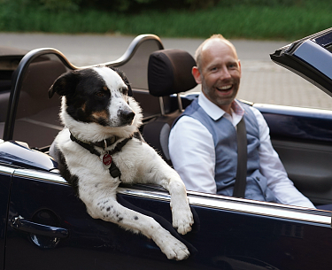 Hund George und Gastgeber Patrick Wulf sitzen im Auto