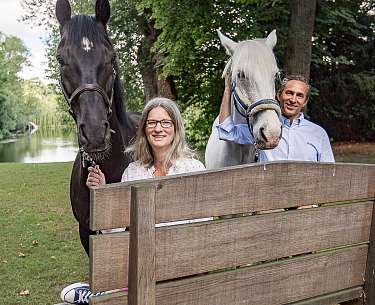Christiane und Heiko Löfken mit zwei Pferden im Garten des Romantik Hotel Hof zur Linde