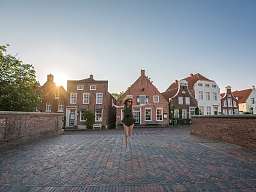 Frau springt auf einer Brücke an der Nordsee