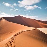 Eine große Sanddüne mit Fußspuren an einem Sommertag in Namibia 