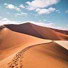 Eine große Sanddüne mit Fußspuren an einem Sommertag in Namibia 