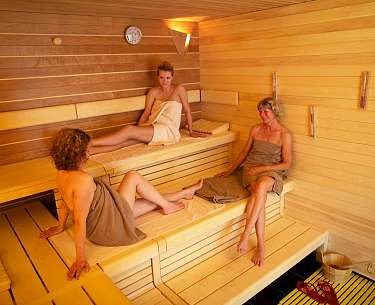 Blick in eine Holzsauna mit drei Frauen