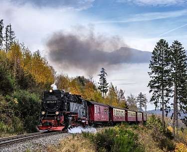 Blick auf eine fahrende Dampflok im Gebirge