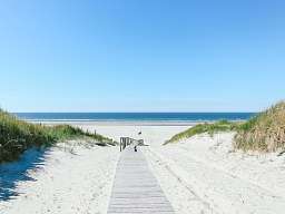 Blick auf einen Nordseestrand mit blauem Himmel und Sand