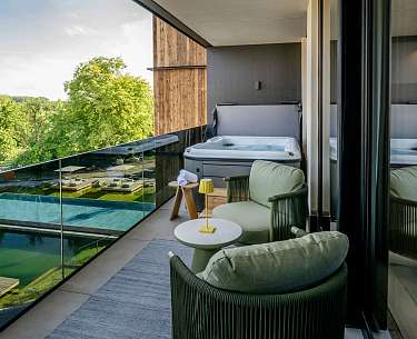 Gemütlicher und stilvoller Balkon mit Whirlpool und Blick ins Grüne in der Chalet SPA Suite im Romantik Hotel Mühlbach
